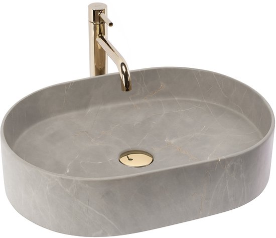 Grijze, ovale opzetwastafel met marmerlook, gouden afvoer en kraan.