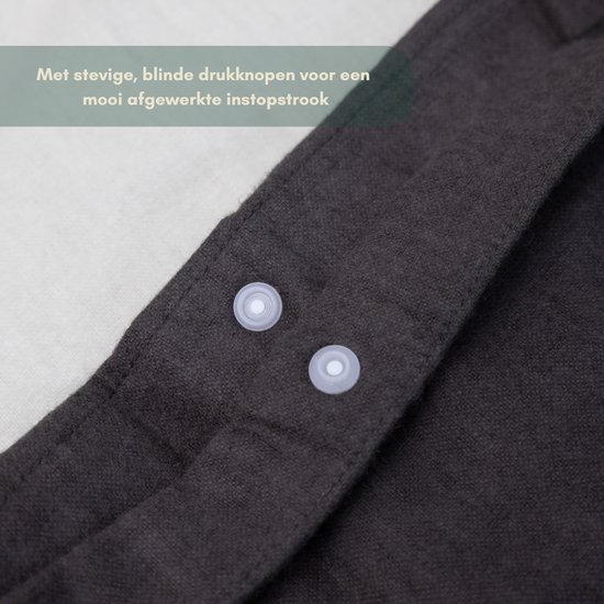 Detail van de drukknoopsluiting op een donkergrijs dekbedovertrek.