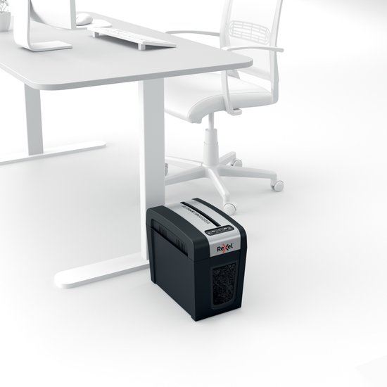 Zwarte Rexel papierversnipperaar naast een bureau op kantoor.