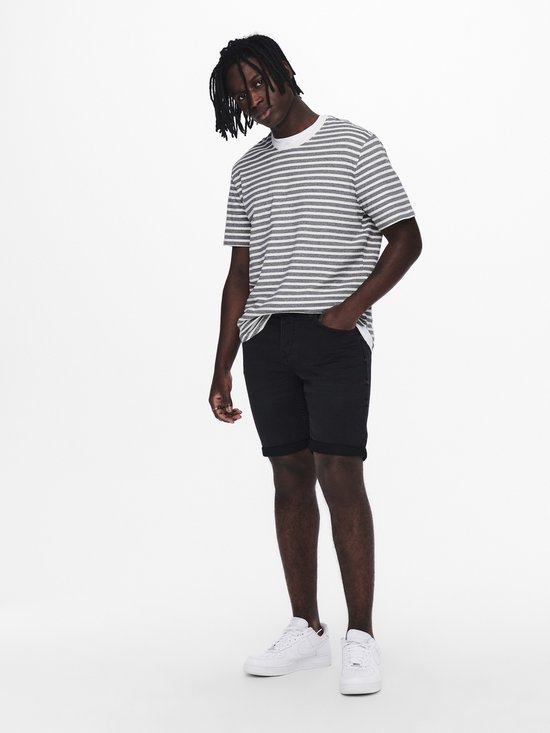 Man met dreadlocks draagt gestreepte t-shirt en zwarte shorts.