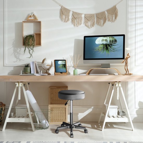 Zwarte draaikruk onder een houten bureau in een moderne werkruimte.