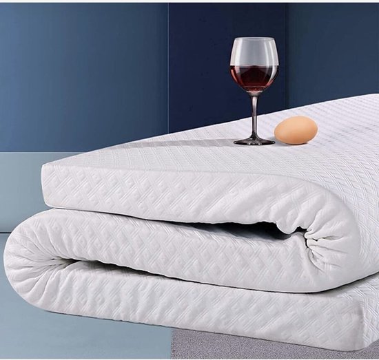 Surmatelas blanc avec motif en losanges, enroulé avec un verre de vin rouge et un œuf dessus.