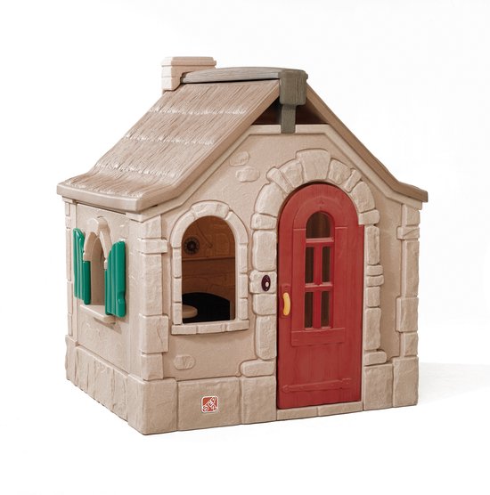 Buitenkant van een bruin speelhuis met rode deur en groene luiken.