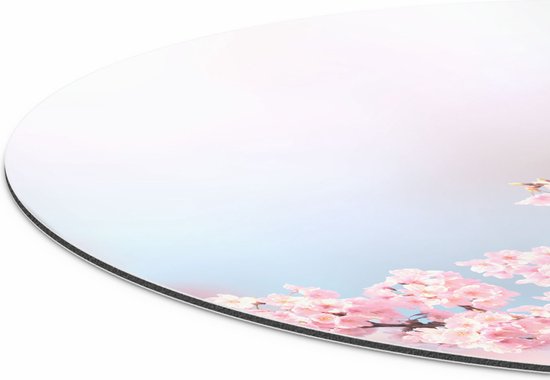 Détail d'un cercle mural rond avec des fleurs roses sur le bord inférieur et un fond doux décoloré.