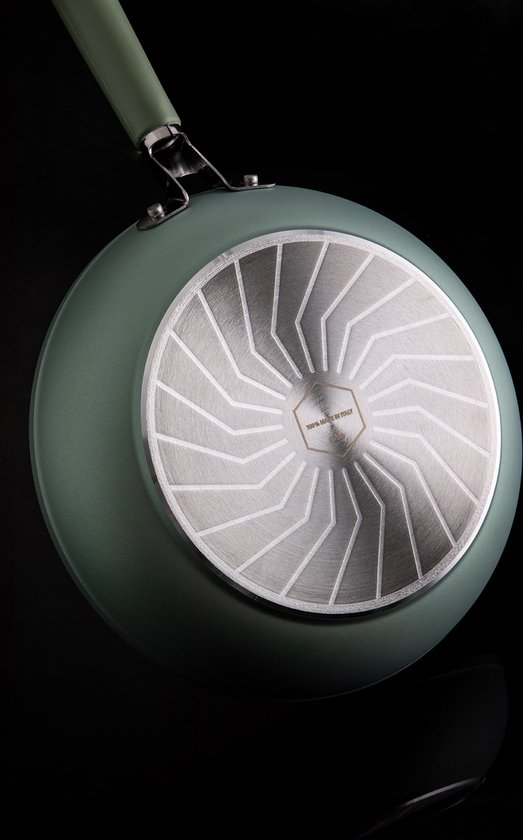 Onderkant van een lichtgroene koekenpan met een cirkelvormig, gestreept metalen inzetstuk. Gemaakt in Italië.