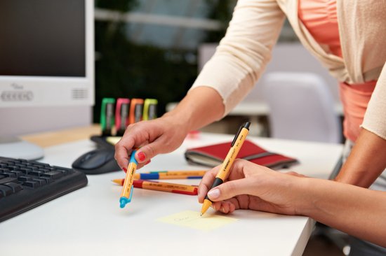 Twee personen die aan een bureau werken, één met oranje STABILO pointball balpen met blauwe grip.