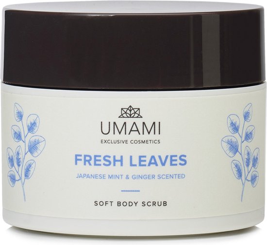 UMAMI Fresh Leaves Soft Body Scrub pot met blauwe blaadjes en tekst: "UMAMI EXCLUSIVE COSMETICS FRESH LEAVES JAPANESE MINT & GINGER SCENTED SOFT BODY SCRUB"