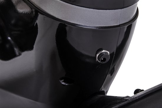 Close-up van de stroomaansluiting aan de onderkant van een zwarte crosstrainer.