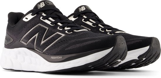 Paar zwarte New Balance sportschoenen met witte zolen, grijze N-logo's en 'Fresh Foam' opdruk.