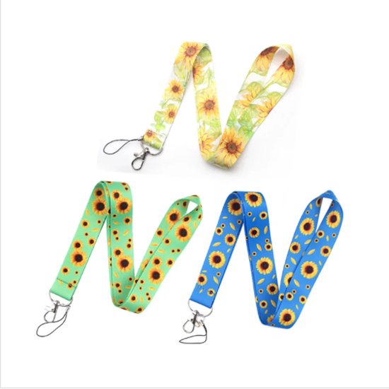 Twee lanyards met zonnebloemmotieven. Eén is wit met gele zonnebloemen, de andere is groen met zonnebloemen en blaadjes, en blauw met zonnebloemen.