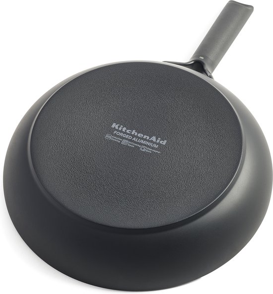 Onderkant van een zwarte KitchenAid koekenpan met tekst "KitchenAid Forged Aluminium".