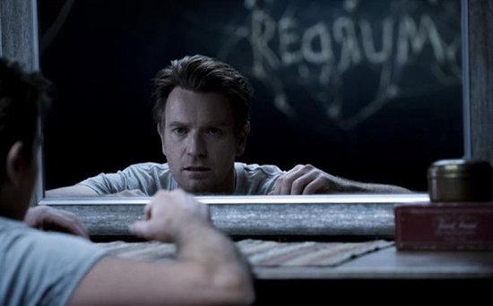 Ewan McGregor kijkt door een raam naar een persoon.