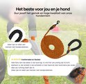Opgerolde oranje hondenriem met zwart gevoerd handvat en karabijnhaak, liggend op gras.