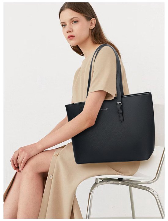 Zwarte Eleganci shopper met schouderbanden, gedragen door een vrouw in een beige jurk.