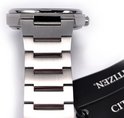 Detail van een Citizen titanium horlogeband met schakels en een deel van de kroon. Een zwart label hangt eraan.