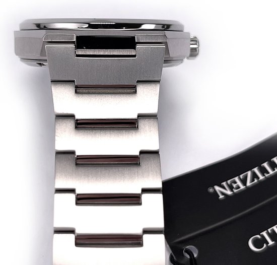 Detail van een Citizen titanium horlogeband met schakels en een deel van de kroon. Een zwart label hangt eraan.