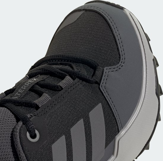 Close-up van de neus van een zwarte Terrex wandelschoen met grijze versteviging en Adidas strepen.