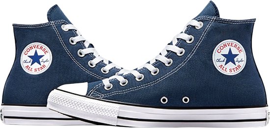 Twee donkerblauwe Converse All Star sneakers met witte veters, witte neuzen en een ronde witte sterapplicatie op de zijkant.