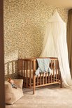 Lichtgroene baby slaapzak over een ledikant in een kinderkamer met perenbehang.