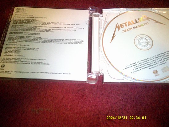 Open cd-hoes van 'Death Magnetic' van Metallica met cd en tekst.