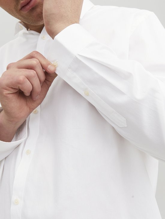 Close-up van de mouw van een wit Jack & Jones overhemd met knopen op de mouwboord.
