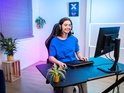 Jonge vrouw met gaming headset gebruikt een zwart, tenkeyless toetsenbord.