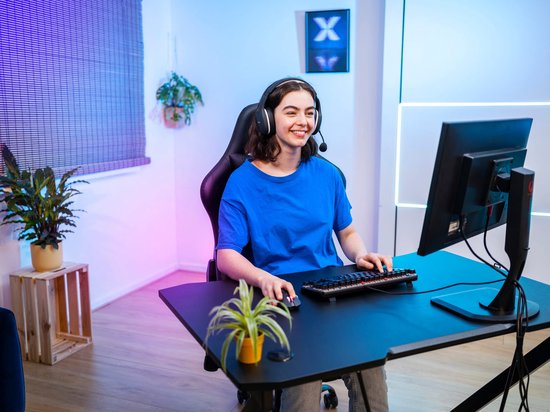 Jonge vrouw met gaming headset gebruikt een zwart, tenkeyless toetsenbord.