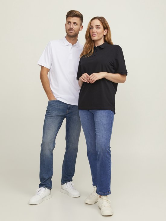 Man in wit poloshirt en vrouw in zwart poloshirt, staand naast elkaar, denim jeans.