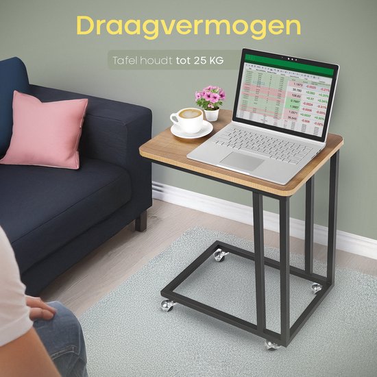 Bijzettafel met houtnerf blad, zwart metalen frame en wielen, met een laptop, koffie en bloemen, naast een bank.