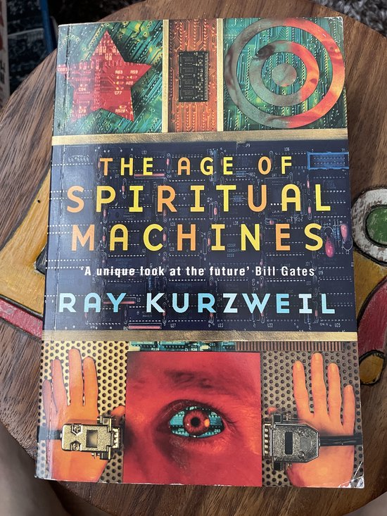 Boek "The Age of Spiritual Machines" van Ray Kurzweil, met een futuristische cover met circuits en een oog.