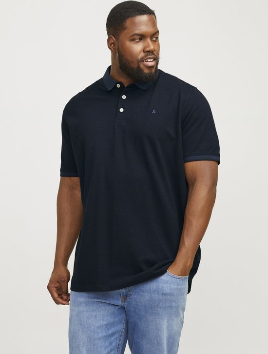 Donkerblauw poloshirt met korte mouwen en knoopjes, gedragen door een man met lichte spijkerbroek.