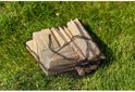 Houten kubben in een zwart netzakje, liggend op groen gras.