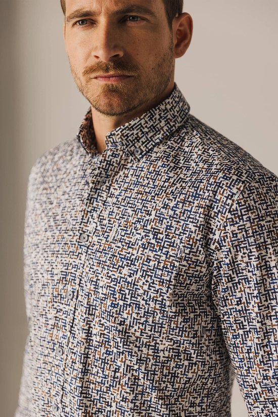 Close-up buste van man met blauw-wit met bruine print overhemd.