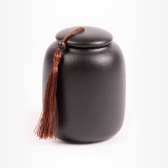 Zwarte, ruw afgewerkte dierenurn met een bruine kwast en touwdetail.