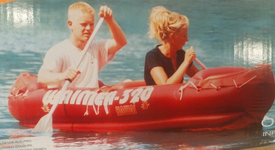Rode 2-persoons kano met de tekst 'whirmer-320 HAWAII'. Een man en een vrouw peddelen.