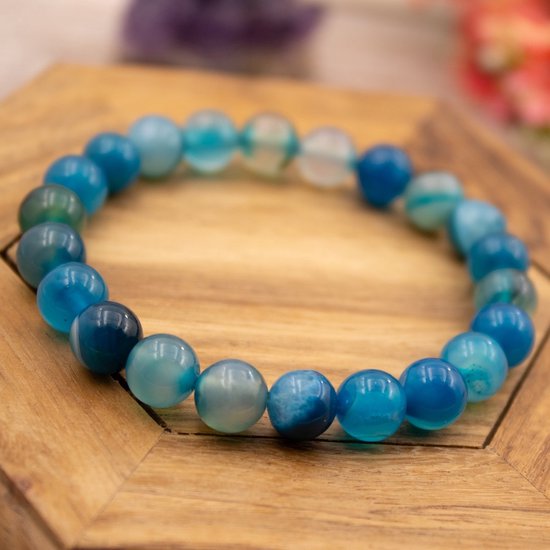 Blauw gestreepte agaat edelsteen armband op een houten ondergrond.