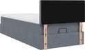 Donkergrijs bed met gestoffeerde opbergruimte, witte matrastopper en rechthoekig zwart hoofdbord.