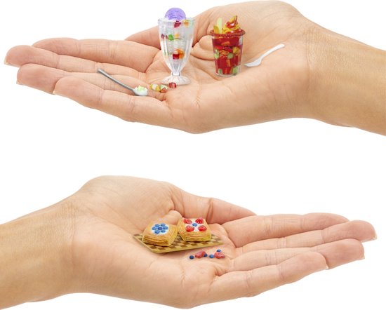 Handen met miniatuur desserts: glas met tropisch dessert, beker met fruit en twee gebakjes met blauwe bessen.