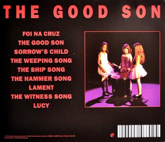 Drie meisjes in witte jurken spelen op een drumstel en de tekst 'THE GOOD SON' in grote rode letters.