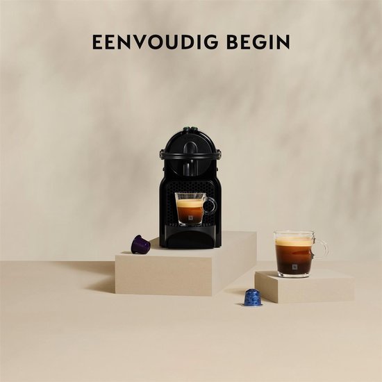 Machine à café à capsules Nespresso noire avec un verre d'espresso, photographiée avec des capsules.