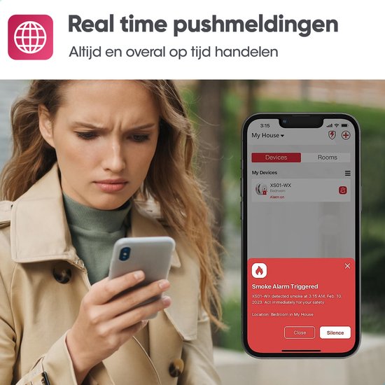 Vrouw kijkt bezorgd naar smartphone met pushmelding van rookmelder alarm. Real time pushmeldingen, altijd en overal op tijd handelen.