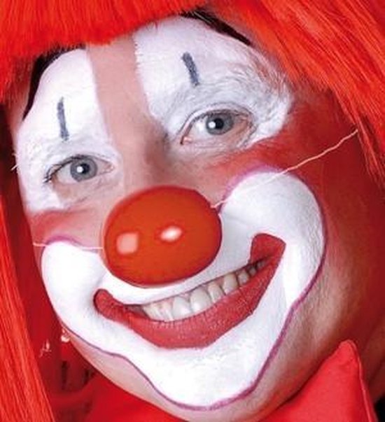 Een clown met rode pruik en rood-witte schmink, met een ronde rode neus.