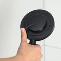 Hand die een matzwarte handdouche vasthoudt om de standen te verstellen.