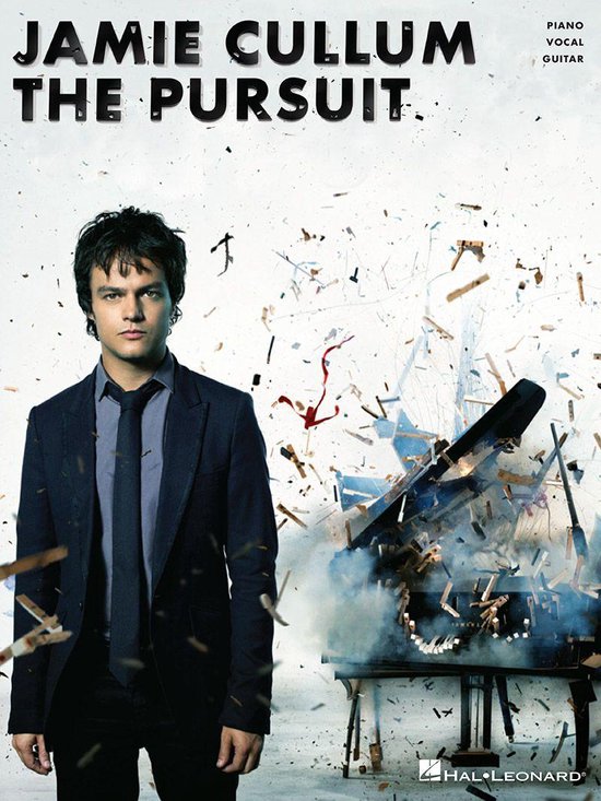 Jamie Cullum in een pak staat voor een exploderende vleugel, met "JAMIE CULLUM THE PURSUIT" erop.
