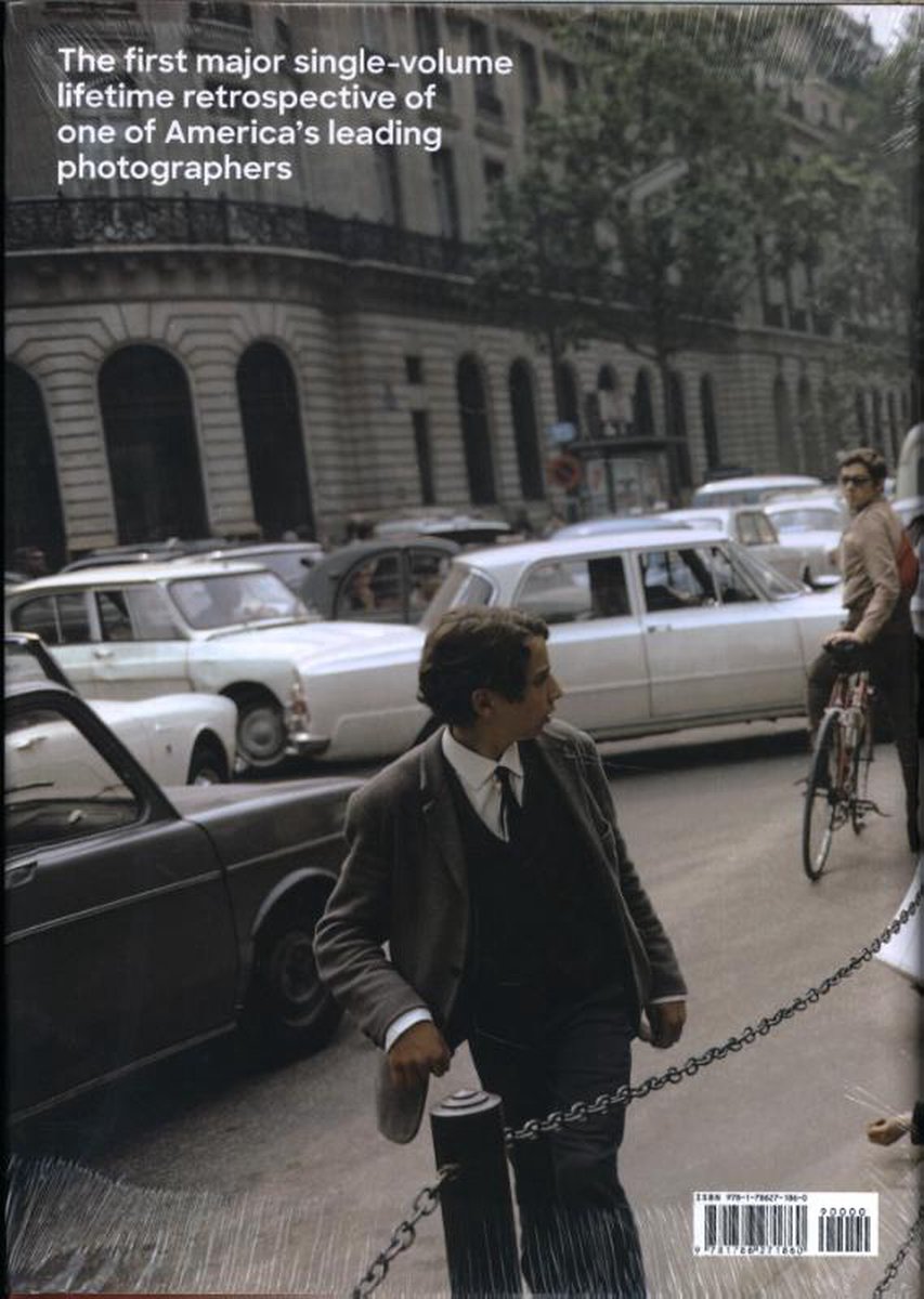 De achterkant van een boek met de tekst 'The first major single-volume lifetime retrospective of one of America's leading photographers'. Een straatscène met auto's en een man op een fiets op de achtergrond.
