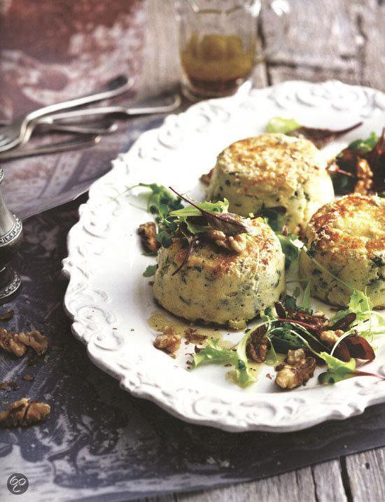 Drie soufflés met salade en walnoten op een sierlijk bord.