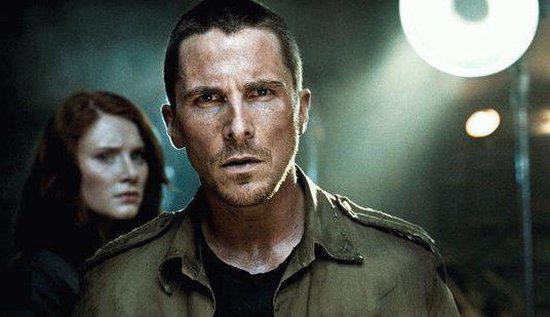 Close-up van Christian Bale met een vrouw op de achtergrond.
