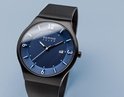 Zwart horloge met blauwe wijzerplaat, zilveren indexen en datum. De wijzerplaat heeft een subtiel kleurverloop van licht naar donker blauw. Milanese band.