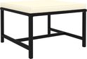 Table basse noire avec coussin crème et un cadre en polyrotin tressé.