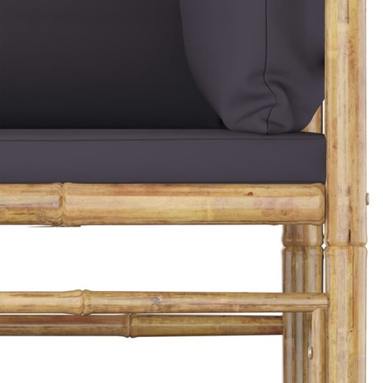 Detail van een bamboe bankframe met een donkergrijs kussen.